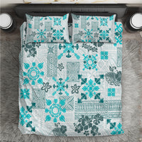 Aqua tribal-pattern quilt bedding set with matching pillow shams, front view on bed