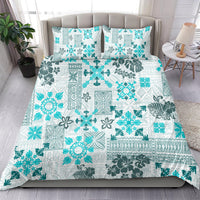Aqua and white tribal quilt bedding set with two pillow shams, spread on bed