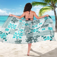 Aqua sarong with dark gray tiki and geometric motifs, flowing tropical quilt-style print