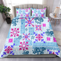 Blue and magenta tribal floral quilt bedding set with two matching pillowcases on bed.