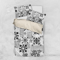 Black-and-white tribal bedding set laid flat with quilt and pillowcases