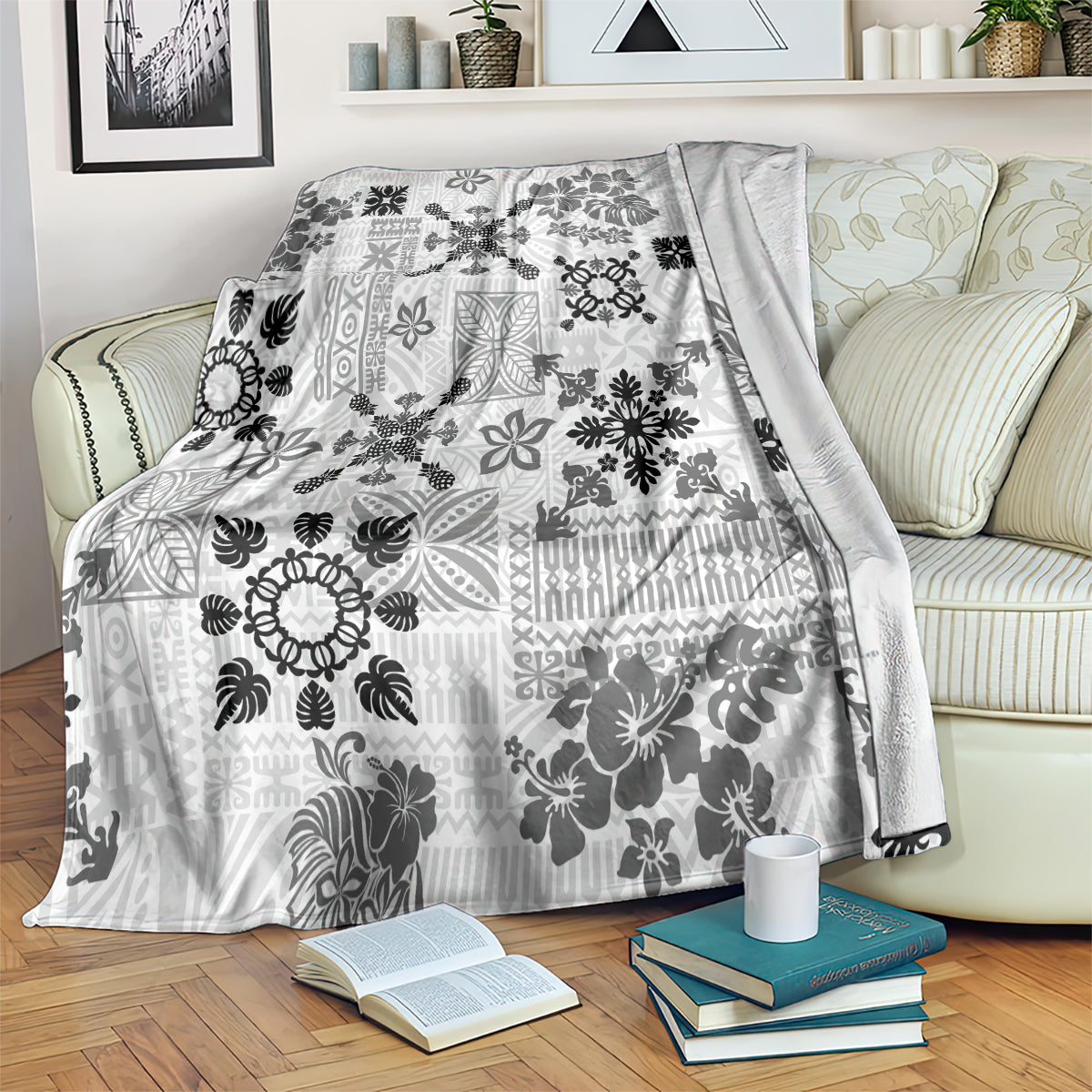 Black and white Hawaiian tapa tribal blanket spread on a bed with floral motif