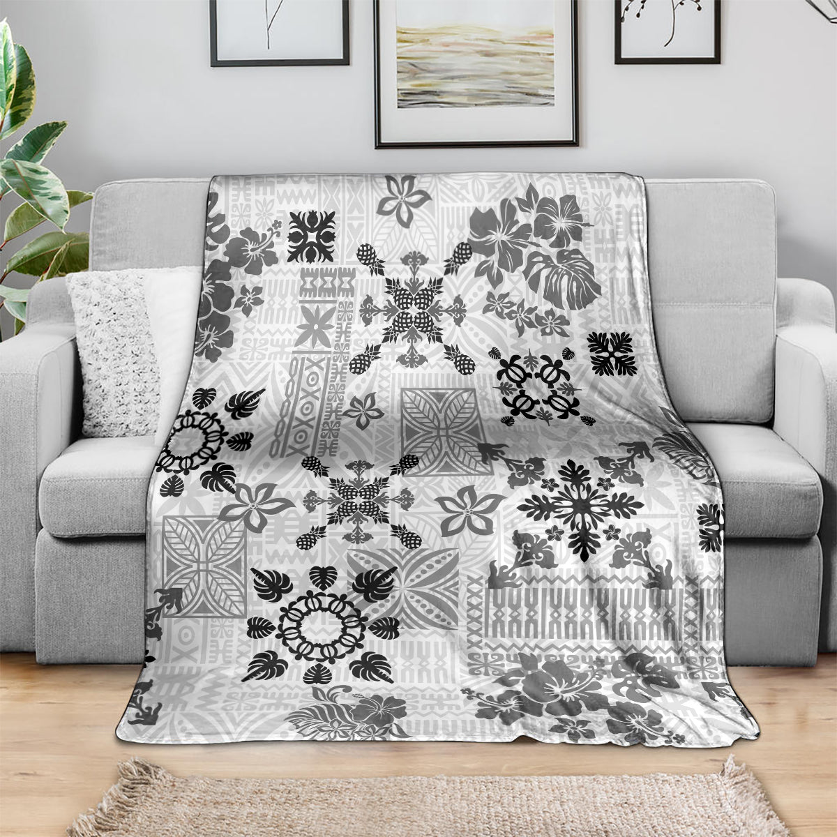 Black and white Hawaiian quilt throw blanket with tapa tribal floral pattern on sofa