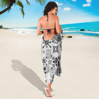 Black and white tapa tribal quilt sarong worn from behind, with repeating floral and border pattern