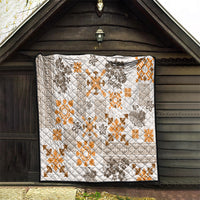 Hawaiian tapa style quilt hanging on a wooden wall, white with orange and dark patterns