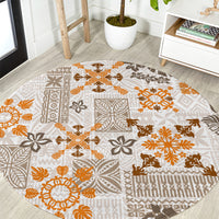 Round area rug with beige base and orange-brown tapa tribal quilt pattern, gold accents