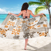 White tapa quilt sarong with orange sunburst motifs and dark brown geometric blocks