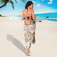 Tapa quilt sarong draped at waist, white base with orange and dark brown motifs
