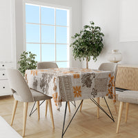 Dining table tablecloth with tropical tapa tribal print, orange accents and brown motifs on off-white.