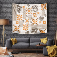 Fringed rectangular tapestry with white, orange, and dark floral quilt pattern