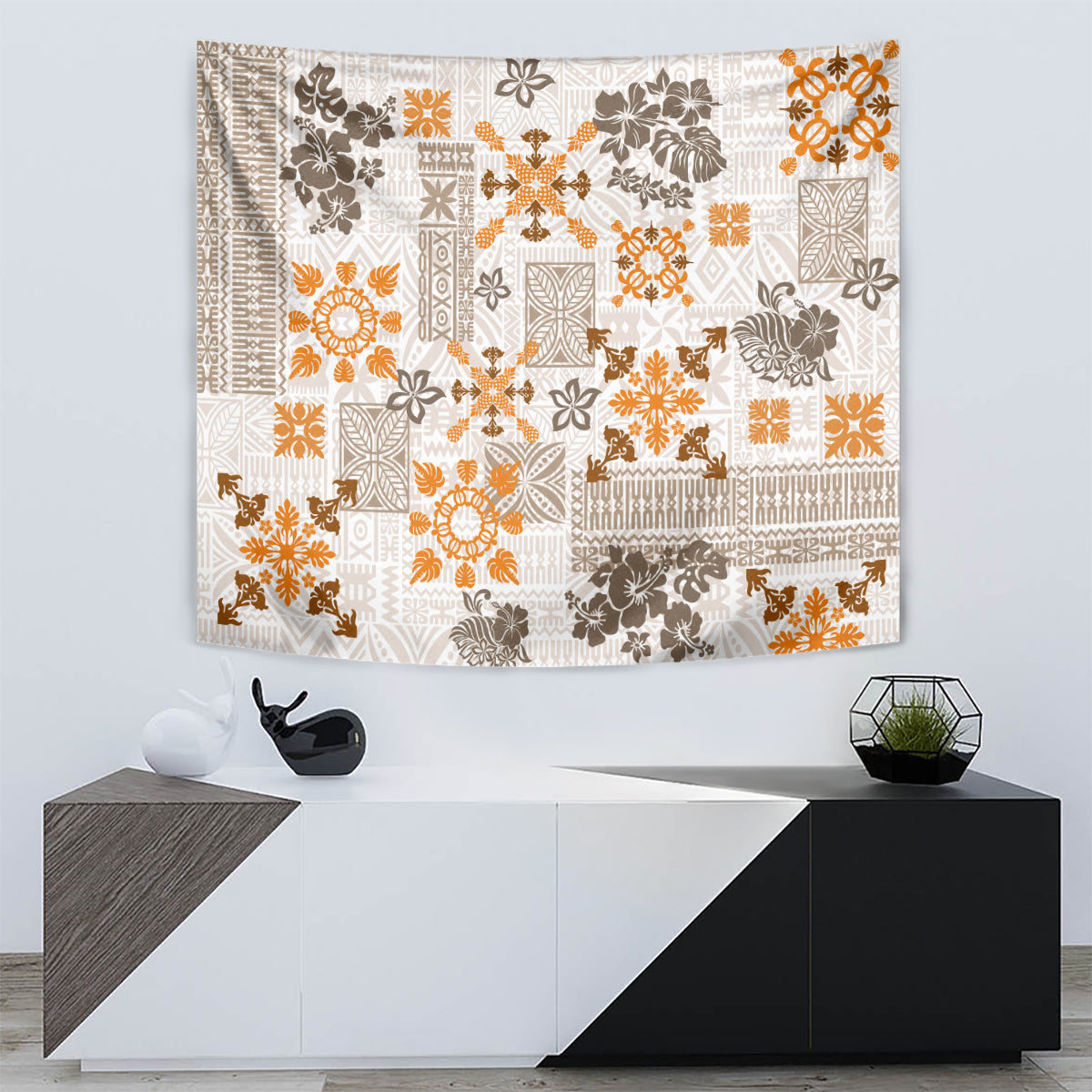 Rectangular fringed tapestry featuring white, orange, and dark floral quilt motifs