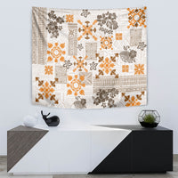 Rectangular fringed tapestry featuring white, orange, and dark floral quilt motifs