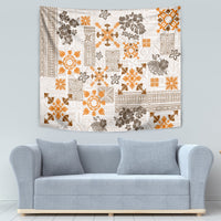 Fringed tapestry wall hanging with white background and orange-and-brown quilt pattern