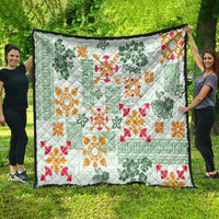 Green tapa tribal quilt with white background, featuring red, orange, and green decorative motifs