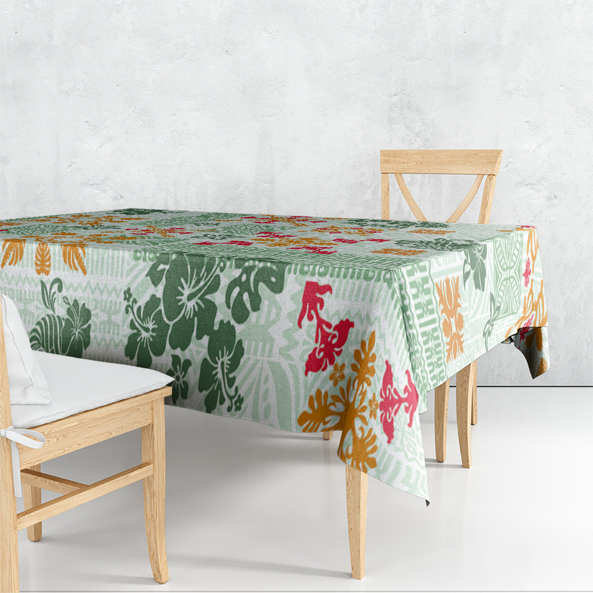 Green patterned tablecloth draped over dining table with tapa, floral, and animal motifs