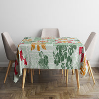 Green square tablecloth with tapa-inspired tribal blocks and colorful floral designs