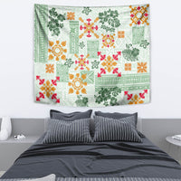 Green quilt-pattern tapestry above bed with floral motifs in orange and red