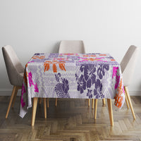 Violet tablecloth with bold patchwork print, orange flowers and pink details