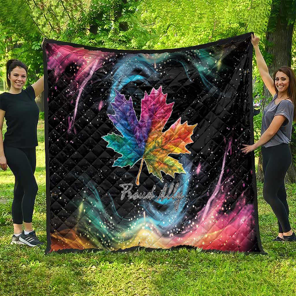 Black quilt blanket draped outdoors with rainbow maple leaf and galaxy swirl artwork