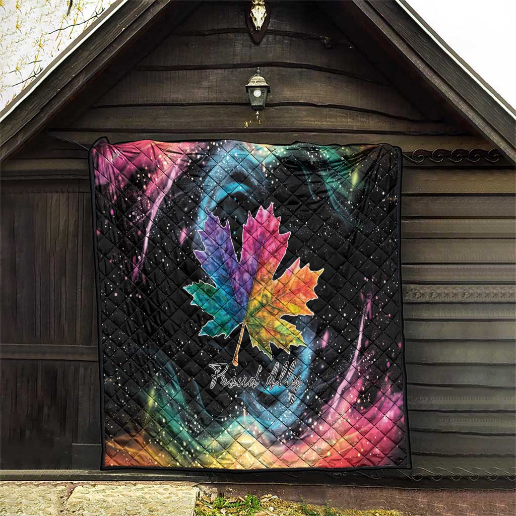 Black quilt on barn wall with rainbow maple leaf, galaxy swirls, and star-speckled pattern