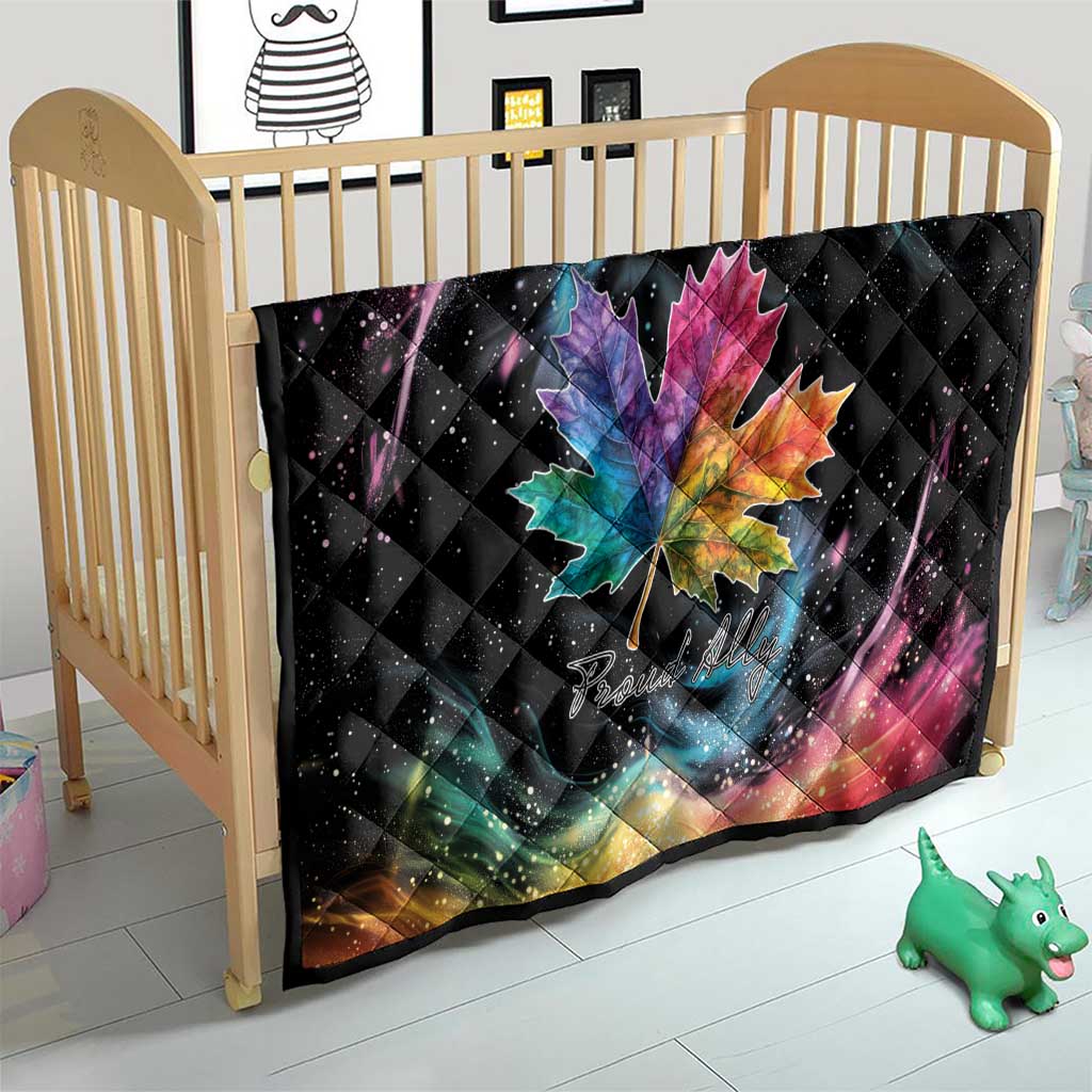 Black quilt blanket on baby crib with rainbow maple leaf and galaxy swirl pattern