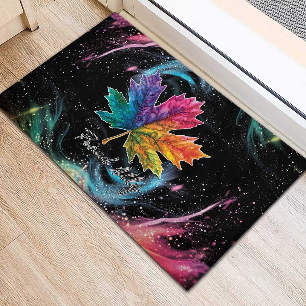 Black rubber doormat with large rainbow maple leaf and “Proud Ally” cursive