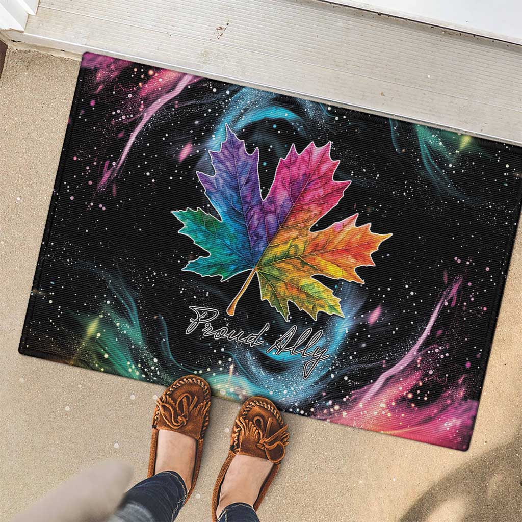 Black rubber doormat showing rainbow maple leaf graphic and “Proud Ally” script