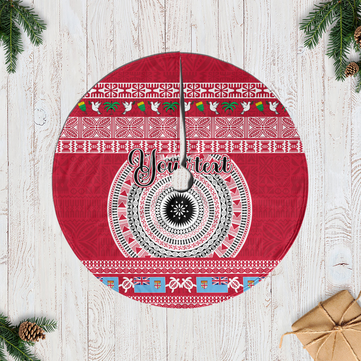 Red round Christmas tree skirt with circular tapa pattern and central 'Joy' text