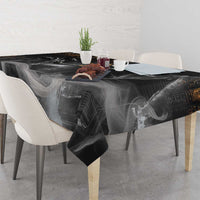 Black tablecloth featuring Anubis face and gold symbols, wrinkled over tabletop.