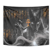 Black rectangular Anubis Egyptian tapestry with orange ankh and gray silhouettes, close-up