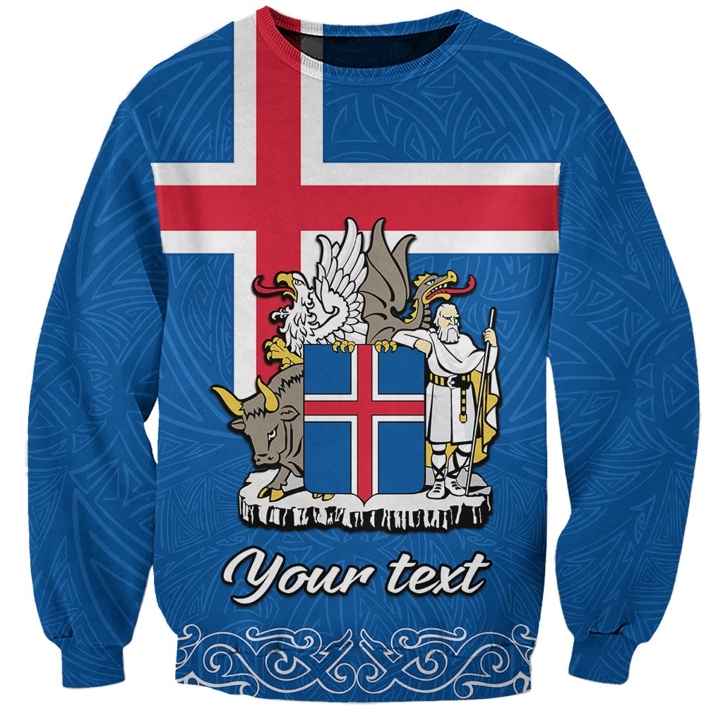 Blue crewneck sweatshirt with Iceland flag and coat of arms graphic, plus cursive text