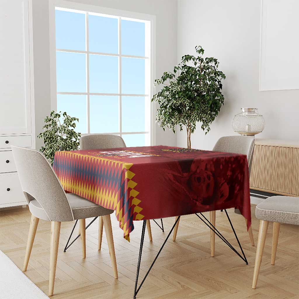 Red tablecloth with geometric diamond pattern and crest graphic, laid over a dining table