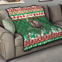 Personalized Christmas moose quilt on a gray sofa, green center with moose graphic and red trim