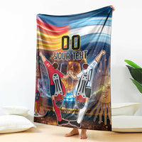 Blue football blanket hanging on sofa with rainbow stripe and '00 YOUR TEXT'