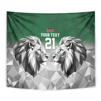 Close-up green tapestry with geometric lion faces, "YOUR TEXT," and "21".