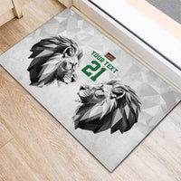 White rubber doormat with lion heads graphic, green “YOUR TEXT” and large 21.