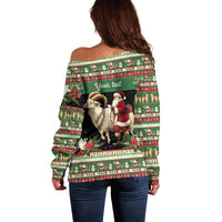 Green off-shoulder sweater, back view with goat and Santa graphic and festive stripe print