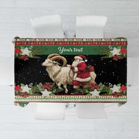 Green holiday tablecloth with goat and Santa print, red holly border
