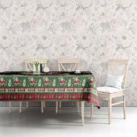 Green Scandinavian holiday tablecloth with goat and Santa motifs, red holly trim