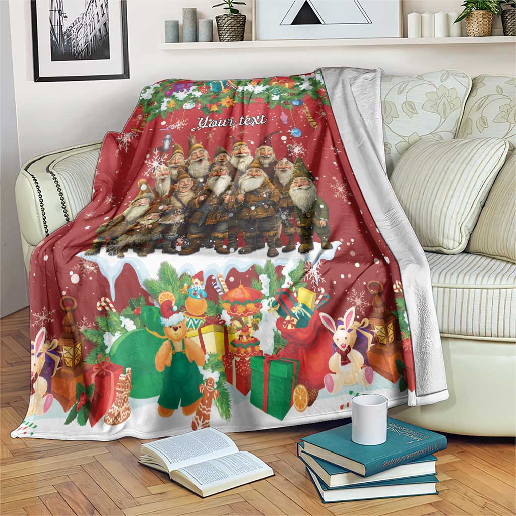 Personalized holiday blanket with red festive scene of gnomes, gifts, and rabbits, draped on a couch