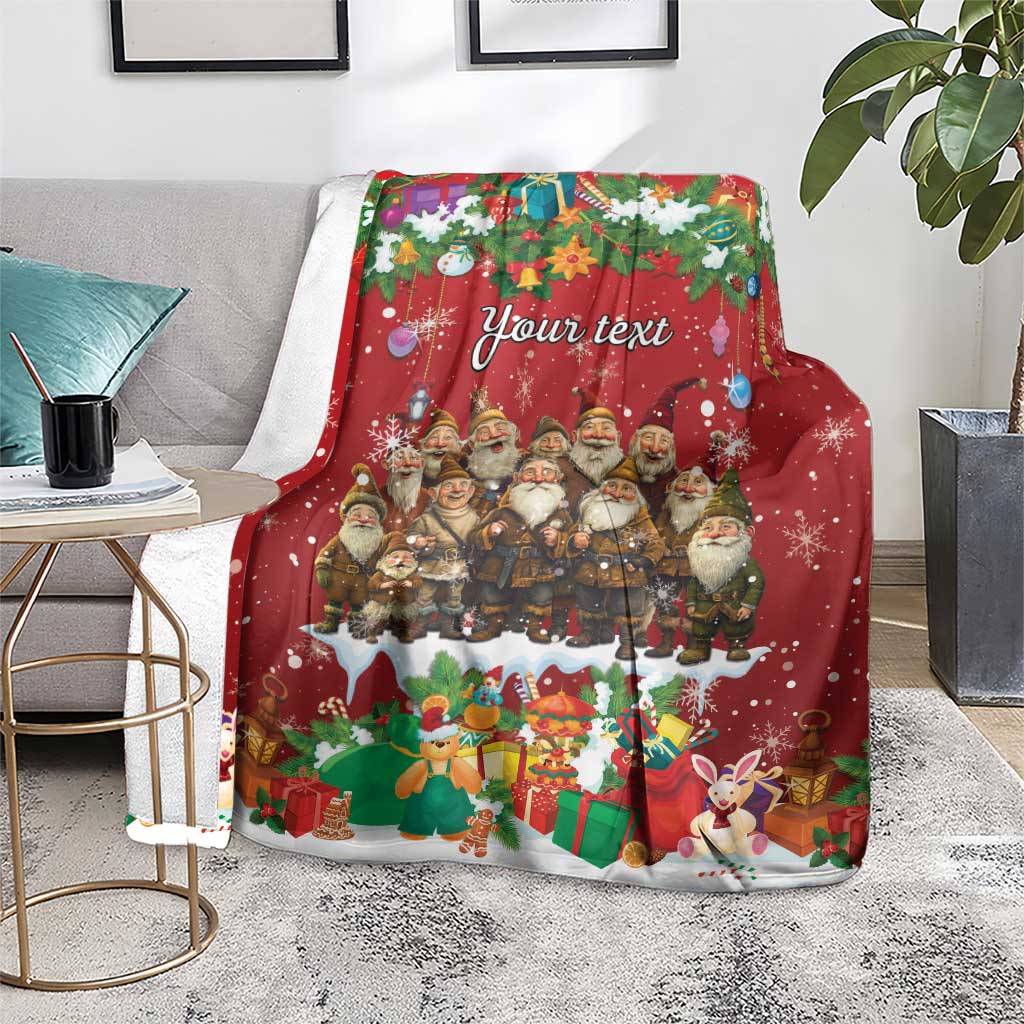 Personalized red holiday blanket with gnome characters, presents, rabbits, and “Your text,” on a living room rug