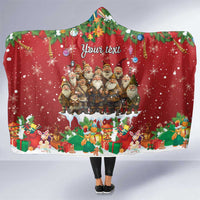 Red hooded blanket with festive village graphic and white sherpa hood lining