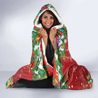 Red hooded blanket with colorful holiday print and white sherpa hood lining