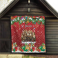 Red personalized quilt hanging on wood wall, "Your text" center design with holiday figures.