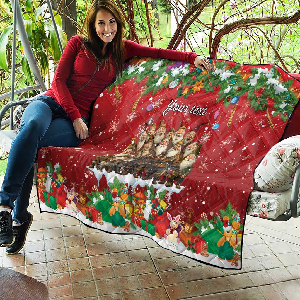 Red personalized quilt outdoors held up, "Your text" design with Yule characters and rabbits.