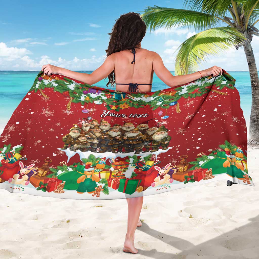 Red holiday sarong draped around shoulders, featuring gnome graphic and gifts