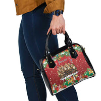 Red and black satchel shoulder bag with long strap and holiday themed artwork.