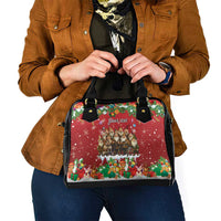 Red holiday shoulder handbag with black handles and front graphic panel.