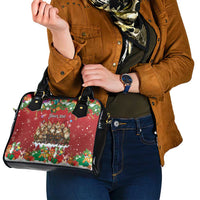 Red holiday handbag with black straps and front festive scene panel.