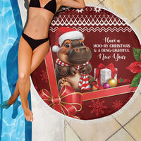 Red round beach blanket with white fringe, hippo Santa hat and gift box holiday print